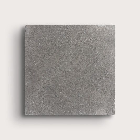 grey square limestone tile on a light grey background