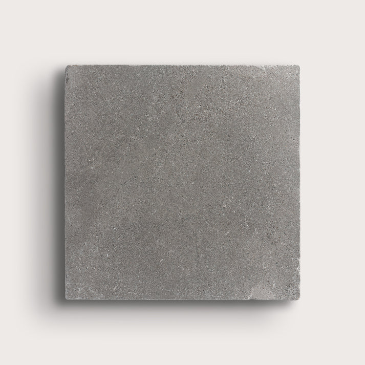 grey square limestone tile on a light grey background