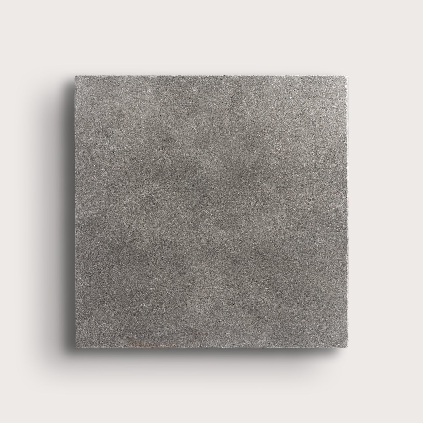 grey square limestone tile on a light grey background