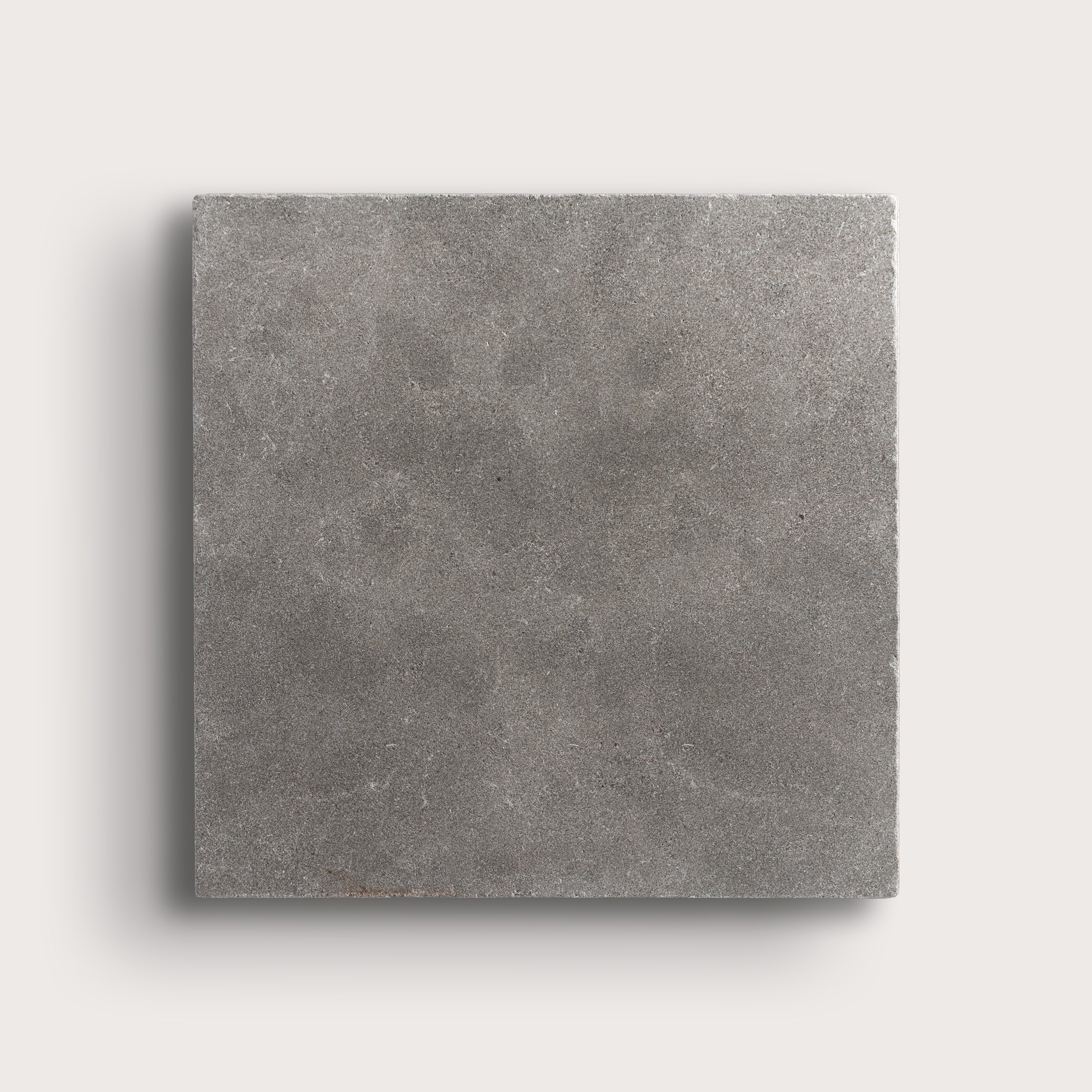 grey square limestone tile on a light grey background
