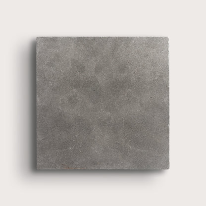 grey square limestone tile on a light grey background