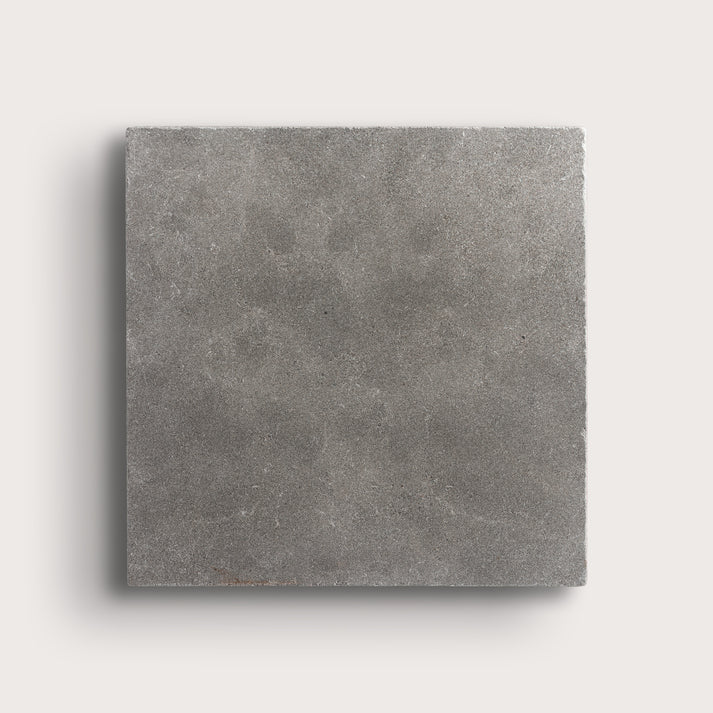 grey square limestone tile on a light grey background