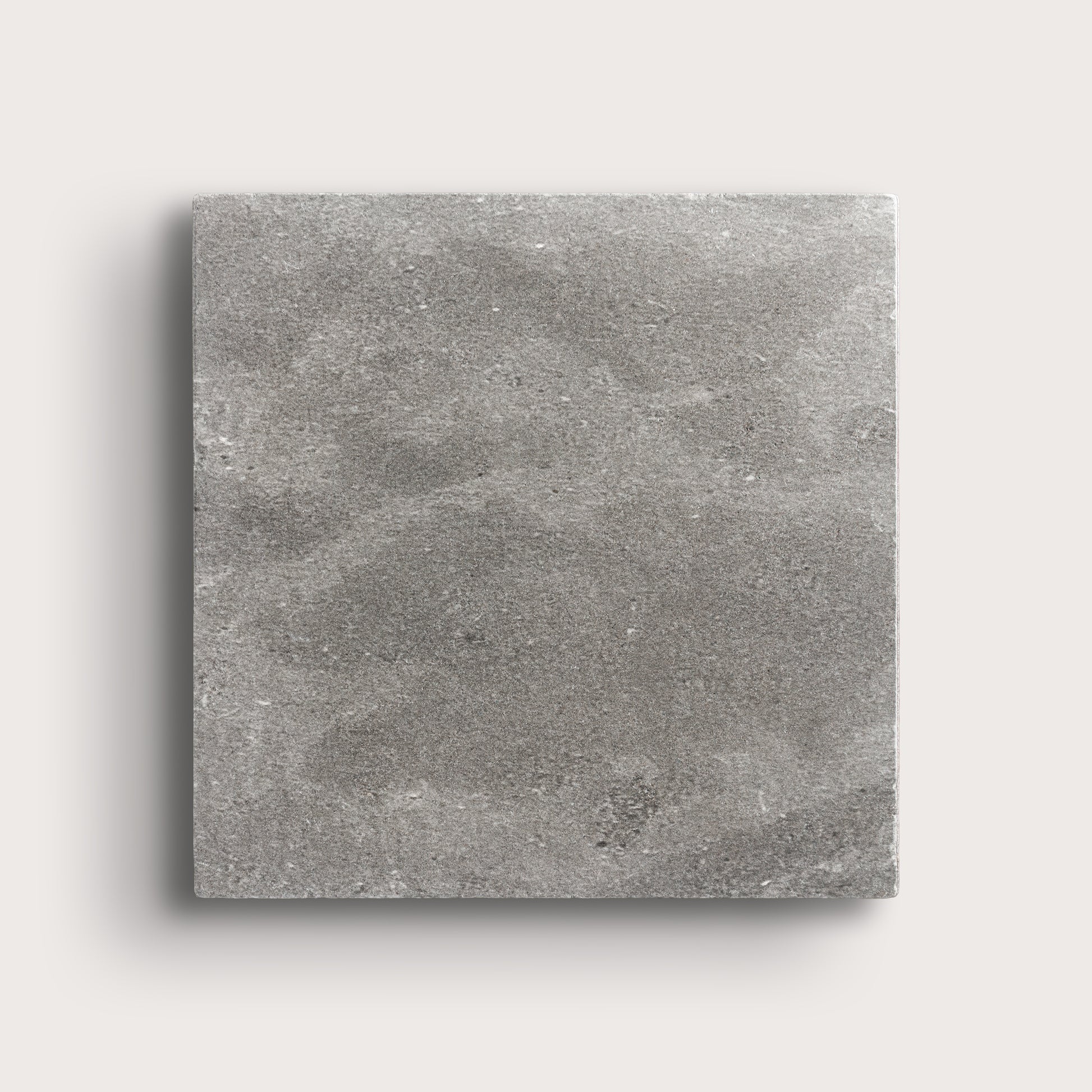 grey square limestone tile on a light grey background