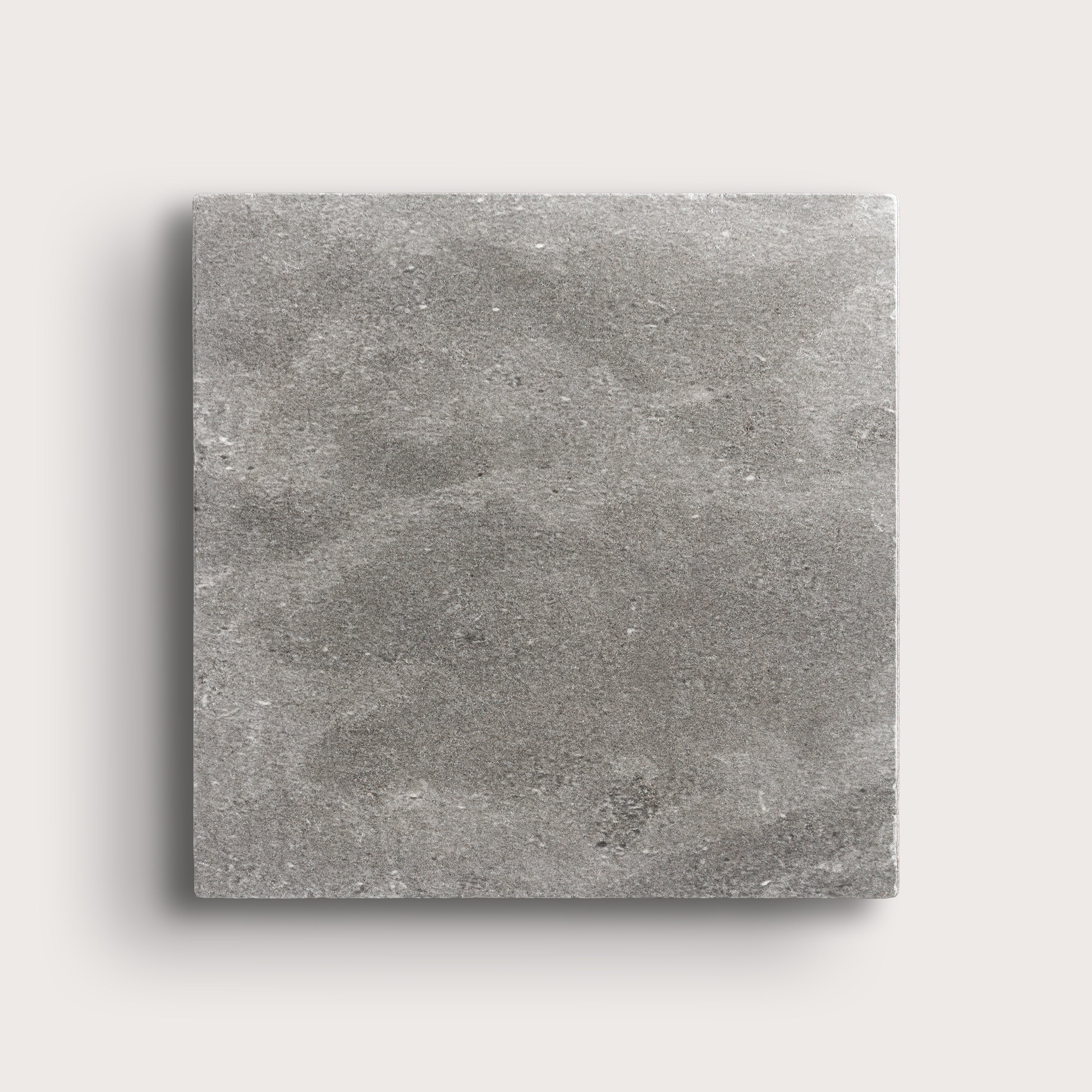 grey square limestone tile on a light grey background