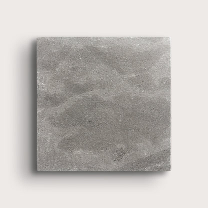grey square limestone tile on a light grey background