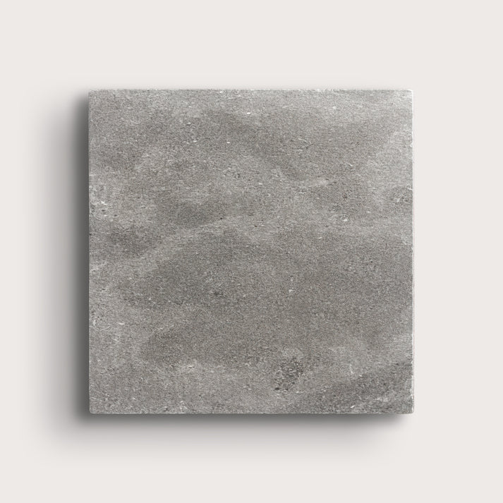 grey square limestone tile on a light grey background