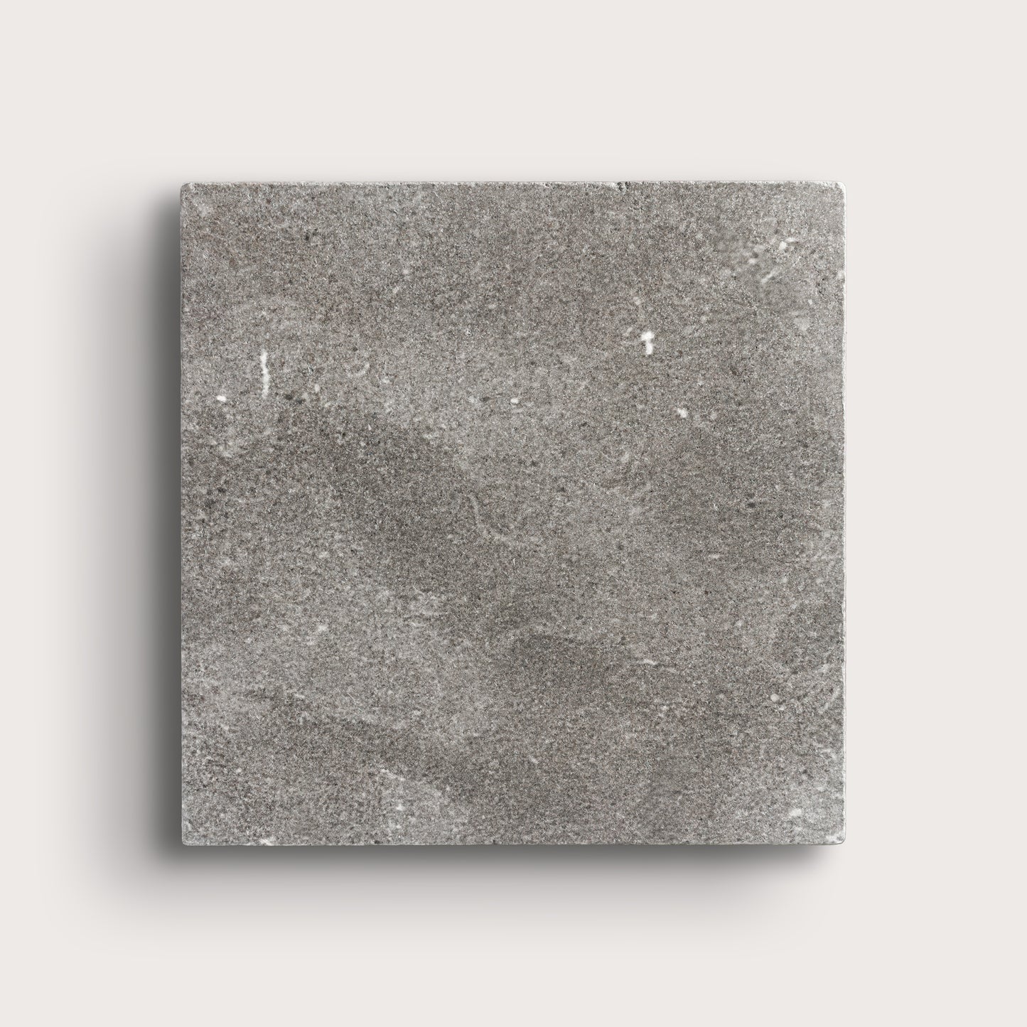 grey square limestone tile on a light grey background