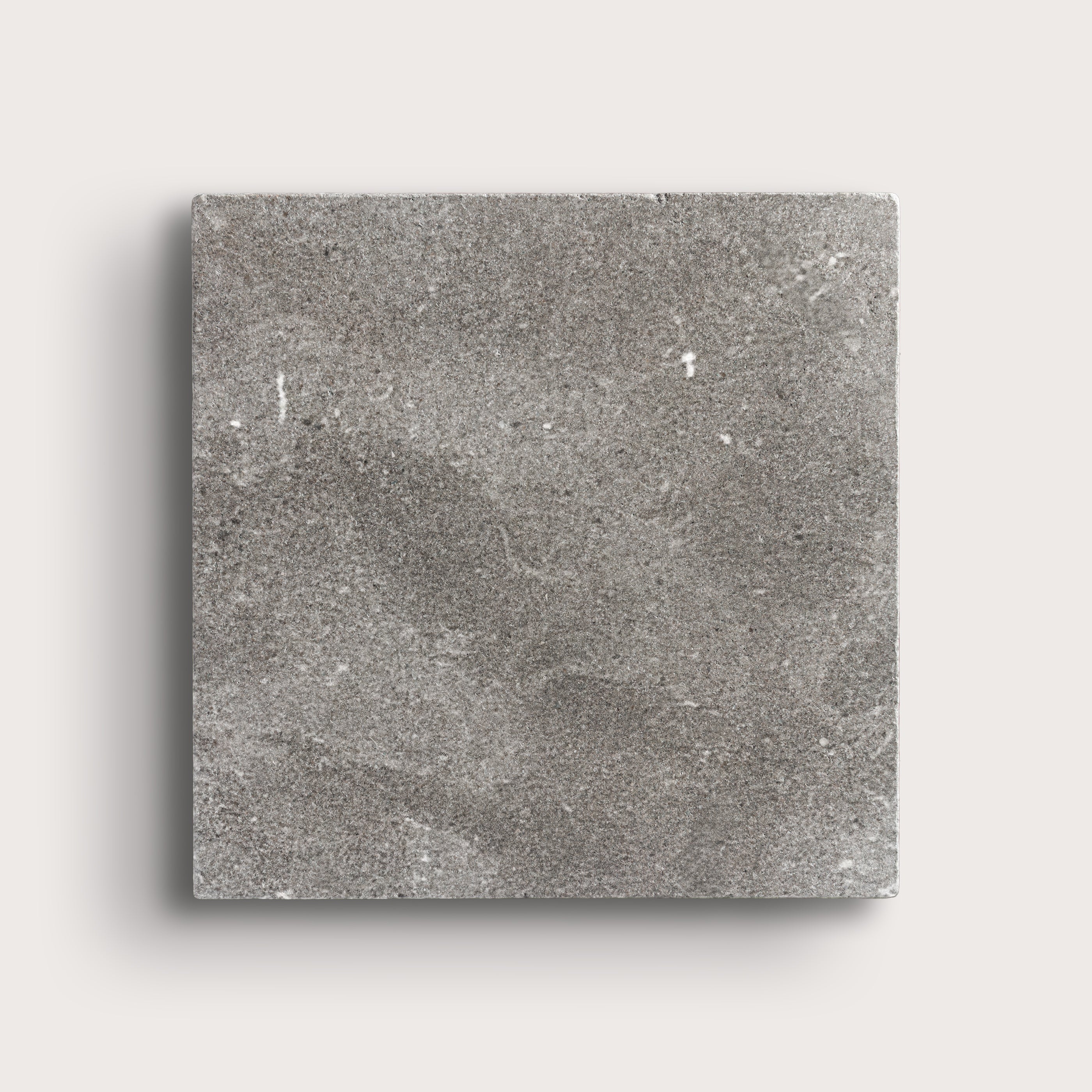 grey square limestone tile on a light grey background