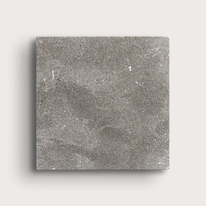 grey square limestone tile on a light grey background