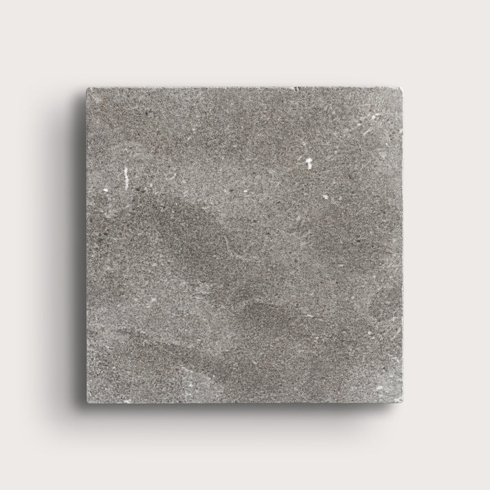 grey square limestone tile on a light grey background