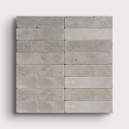 grey rectangle limestone tile in a grid pattern on light grey background