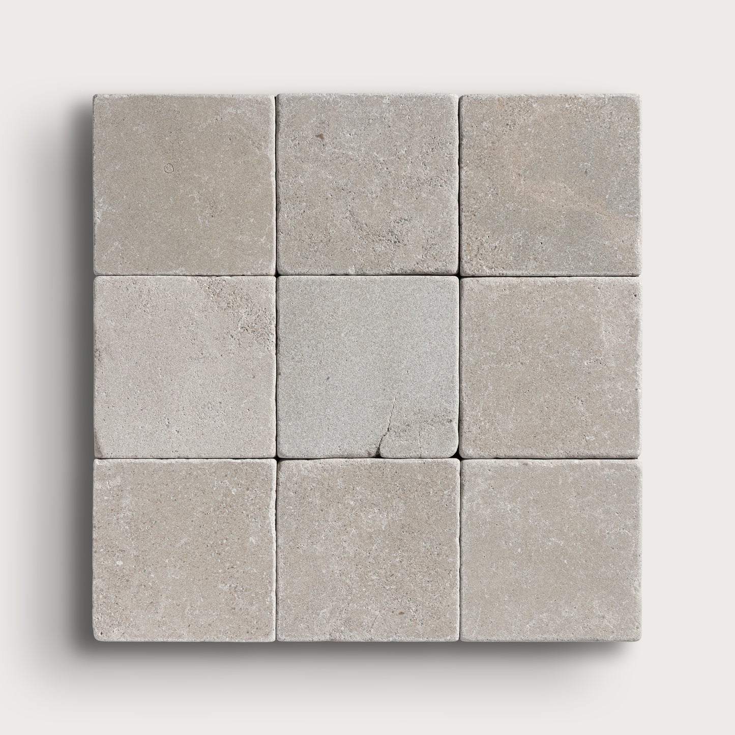 grey limestone square tile in a grid pattern on light grey background