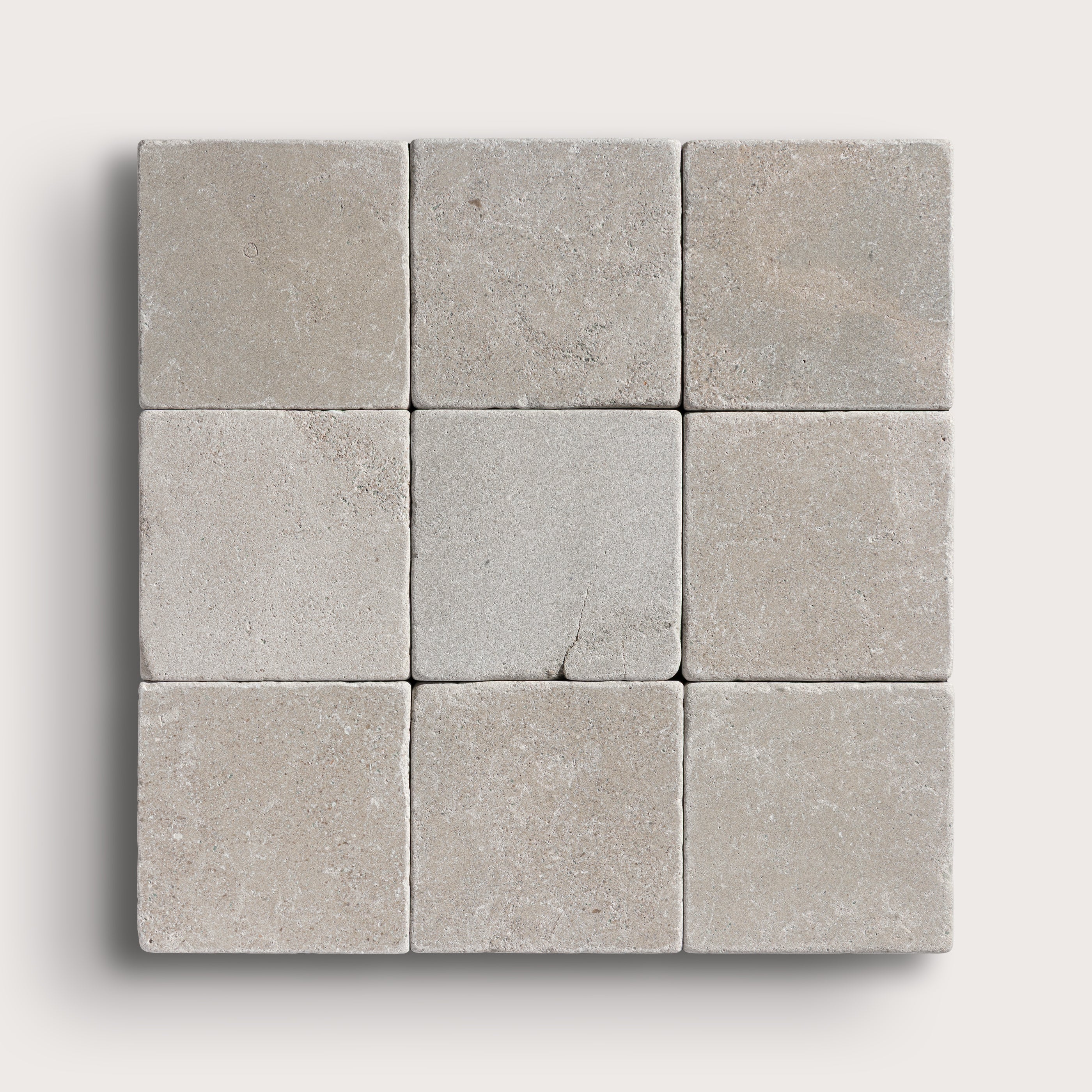 grey limestone square tile in a grid pattern on light grey background