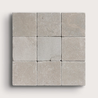 grey limestone square tile in a grid pattern on light grey background