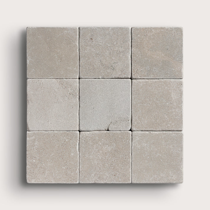 grey limestone square tile in a grid pattern on light grey background