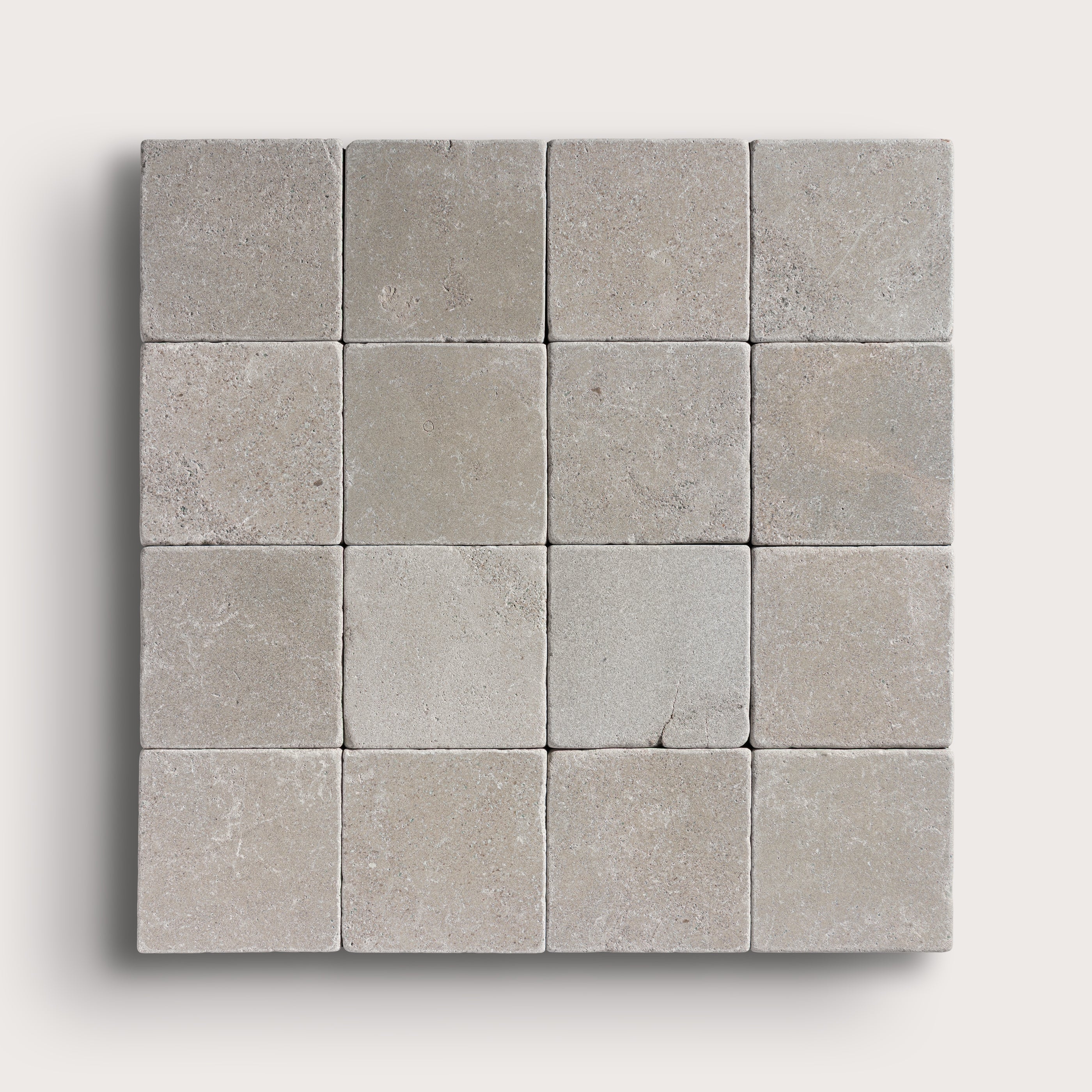 grey limestone square tile in a grid pattern on light grey background