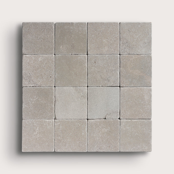 grey limestone square tile in a grid pattern on light grey background
