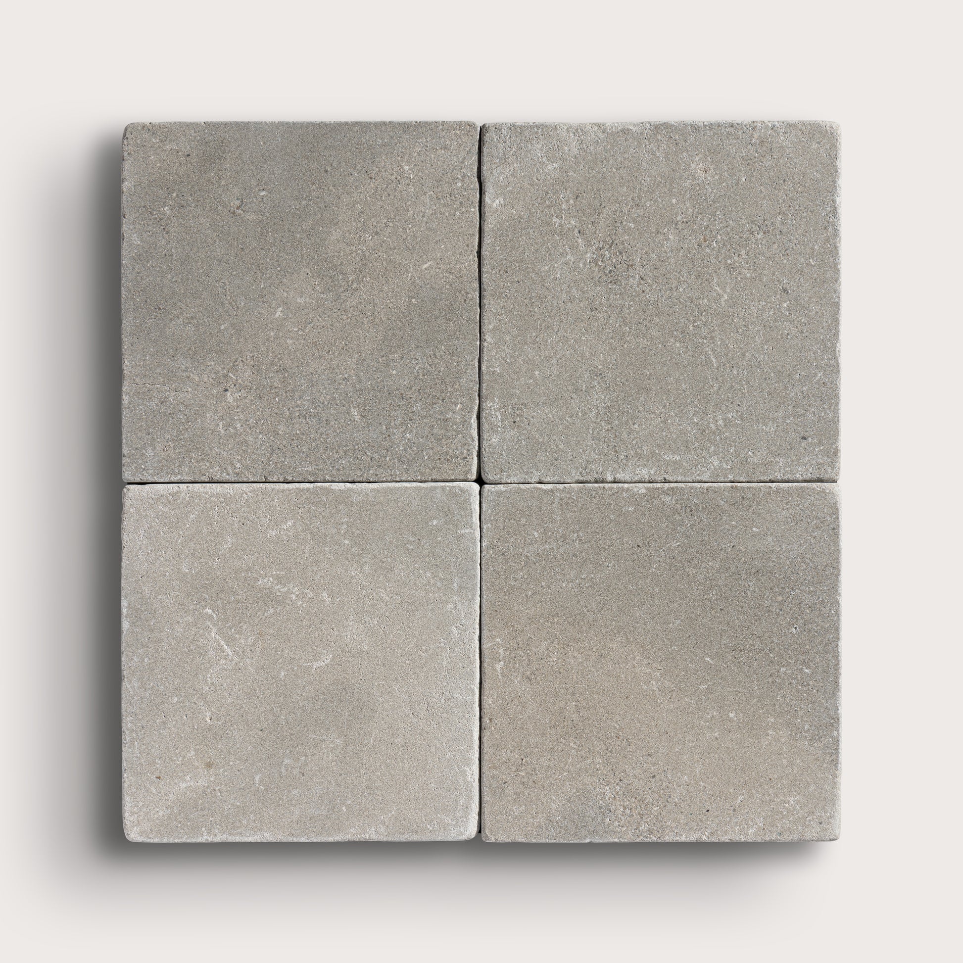 grey limestone square tile in a grid pattern on light grey background