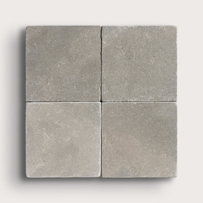 grey limestone square tile in a grid pattern on light grey background