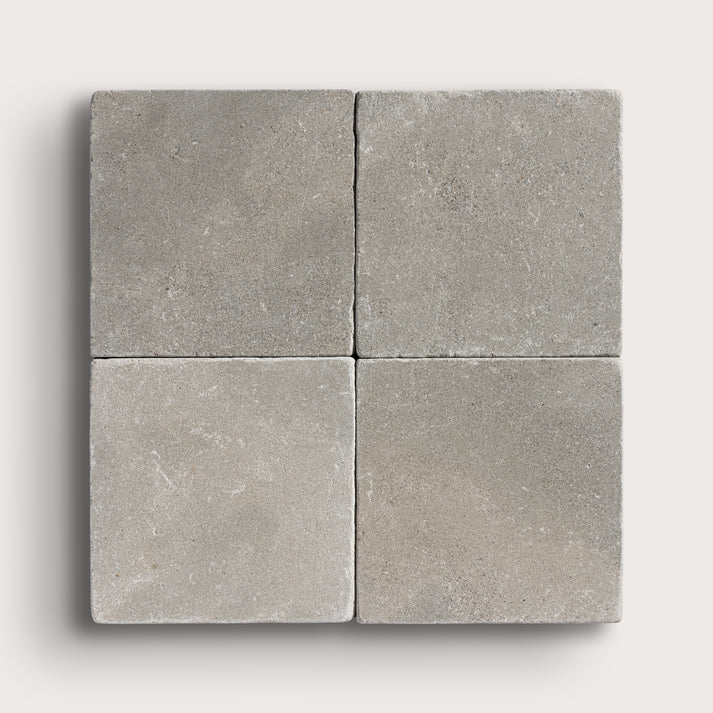 grey limestone square tile in a grid pattern on light grey background