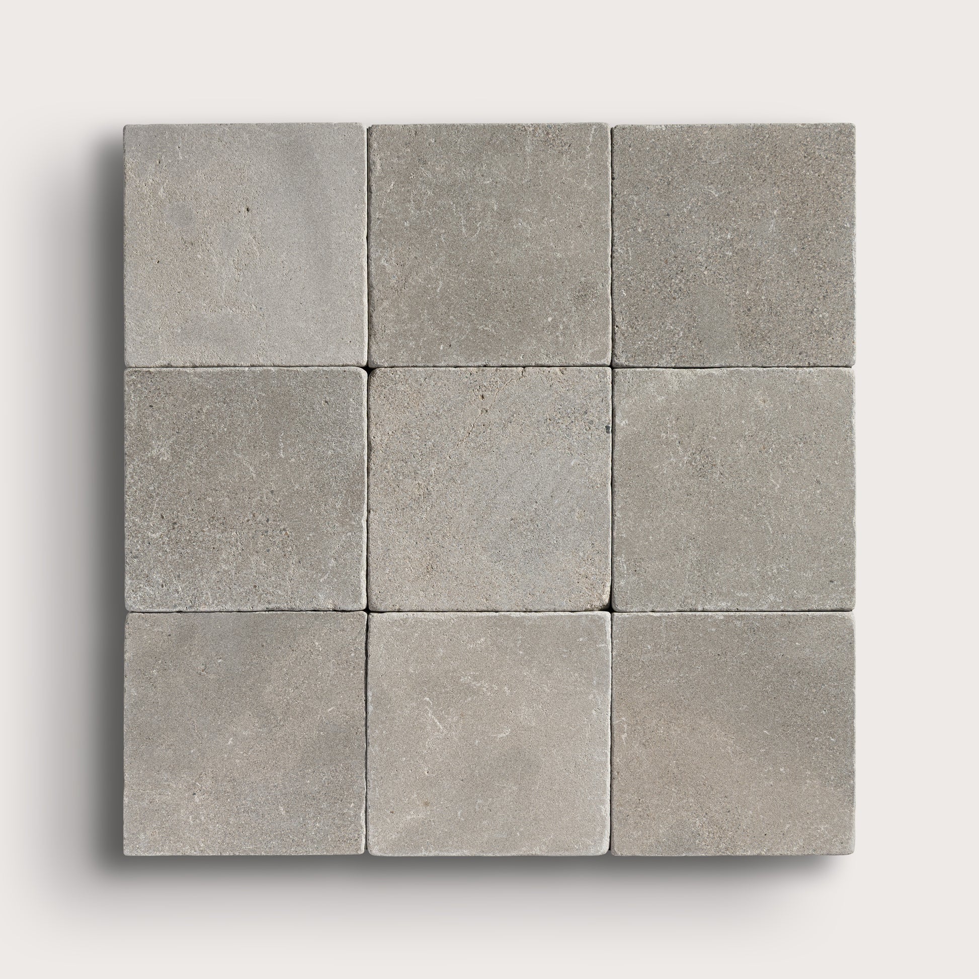 grey limestone square tile in a grid pattern on light grey background