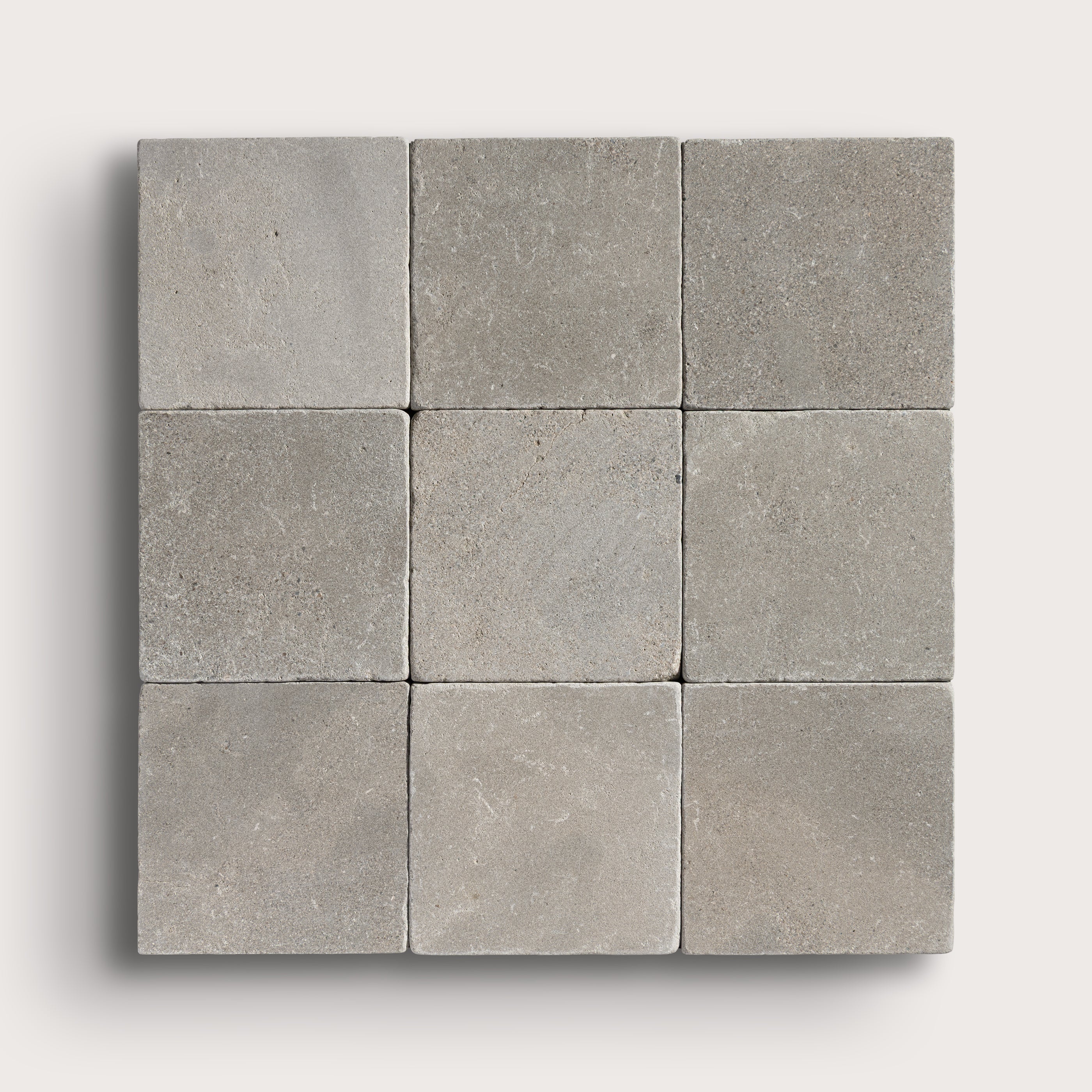 grey limestone square tile in a grid pattern on light grey background