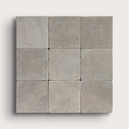 grey limestone square tile in a grid pattern on light grey background