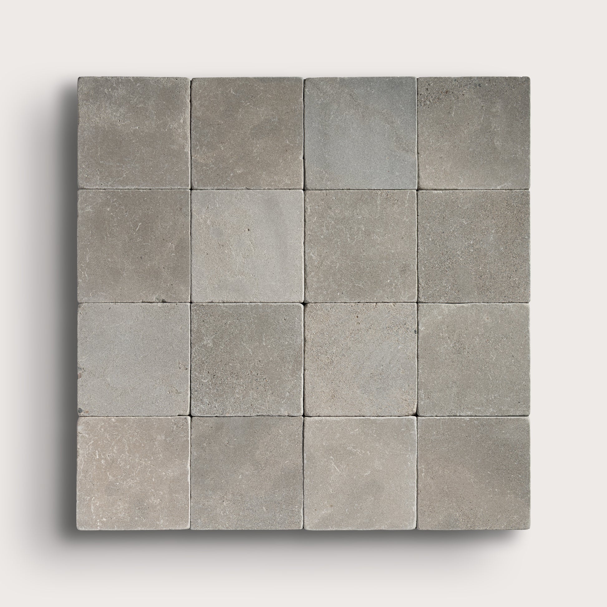 grey limestone square tile in a grid pattern on light grey background