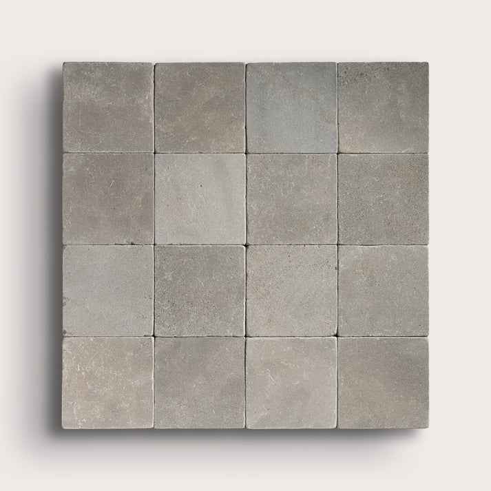 grey limestone square tile in a grid pattern on light grey background