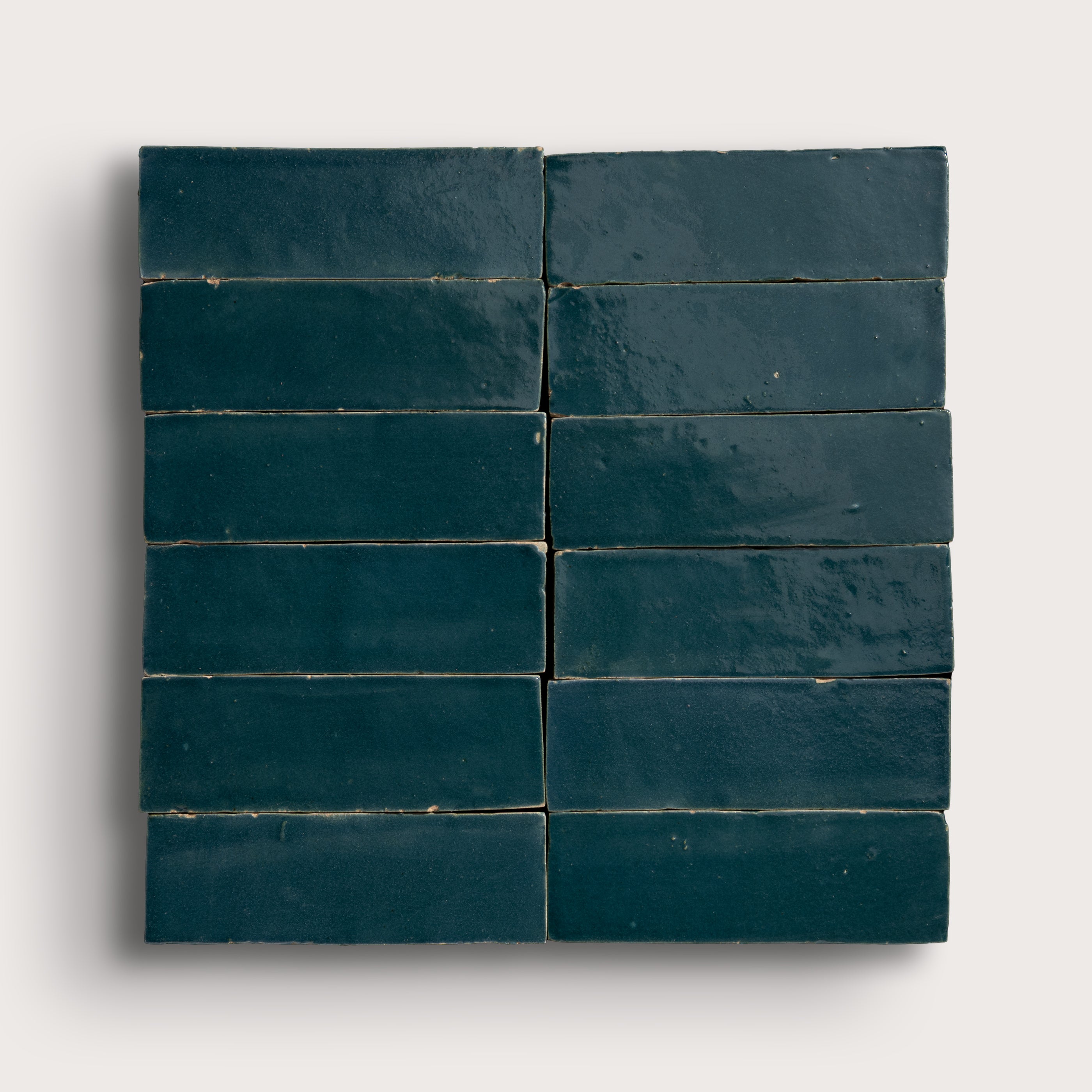 twelve dark blue rectangular zellige tiles arranged in a grid on a white background