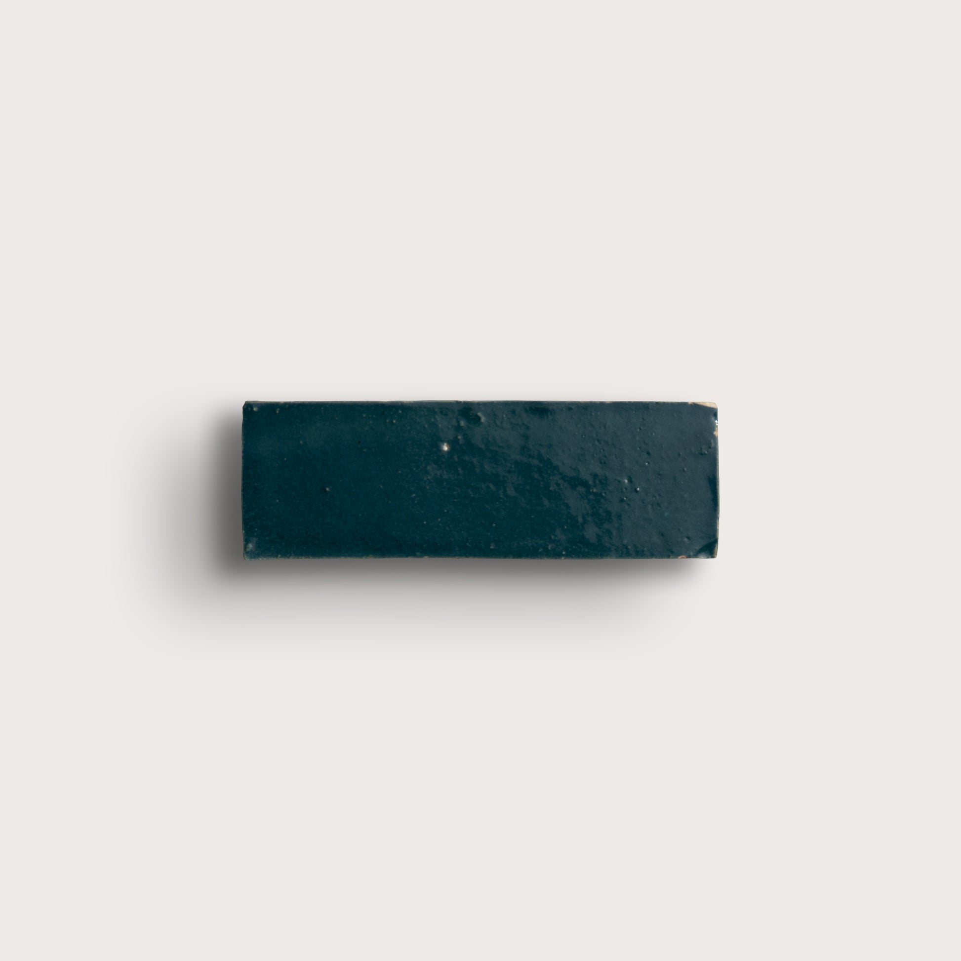 Rectangular zellige dark blue tile on a light gray background