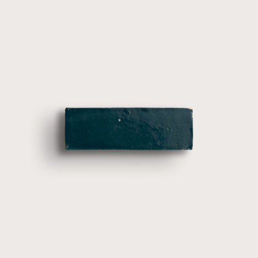 Rectangular zellige dark blue tile on a light gray background