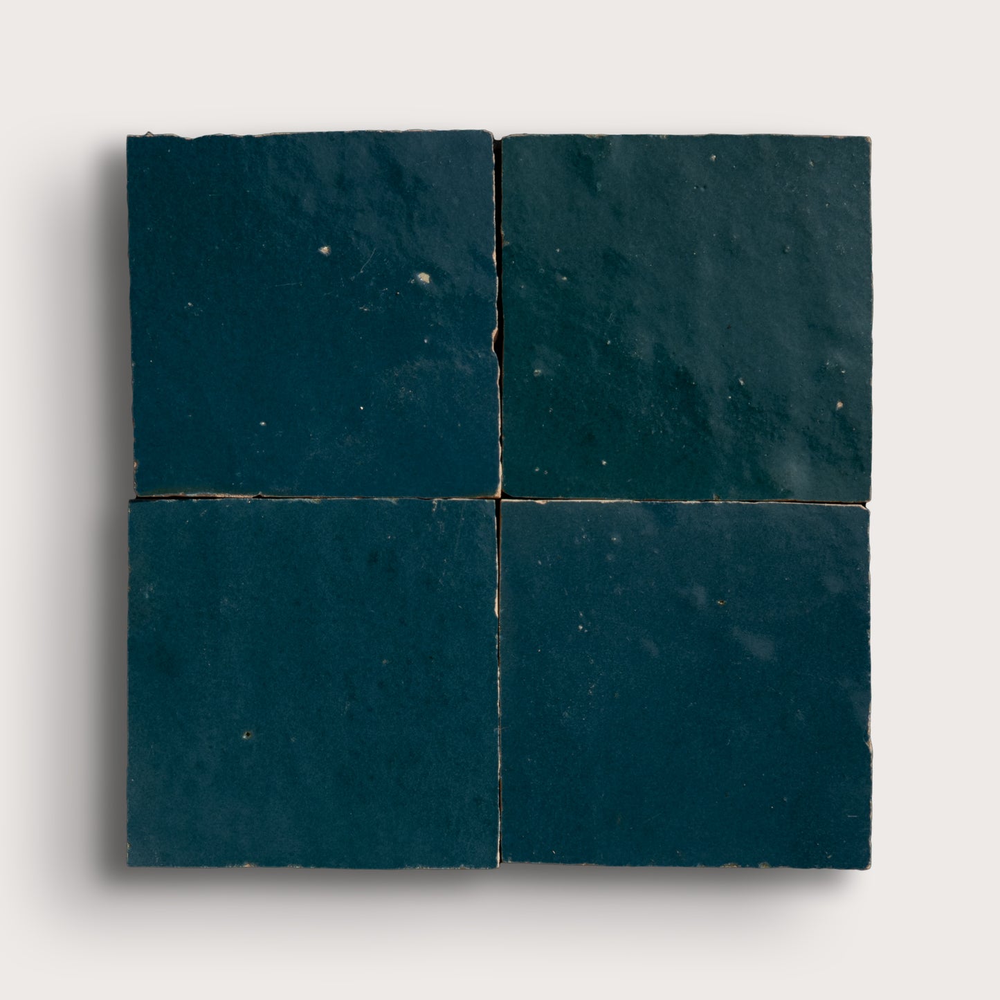 Four dark blue zellige tiles arranged in a grid pattern on a white background