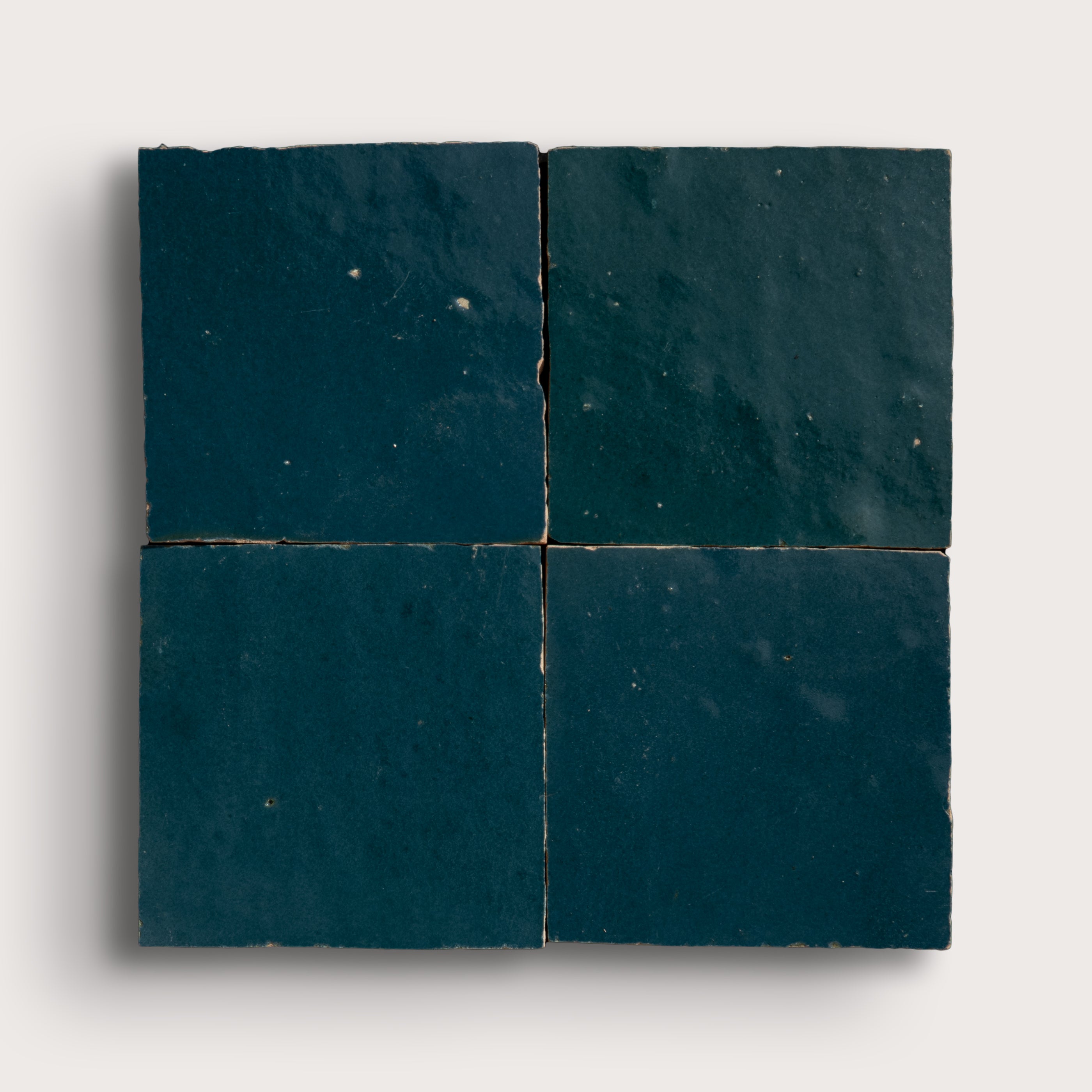 Four dark blue zellige tiles arranged in a grid pattern on a white background