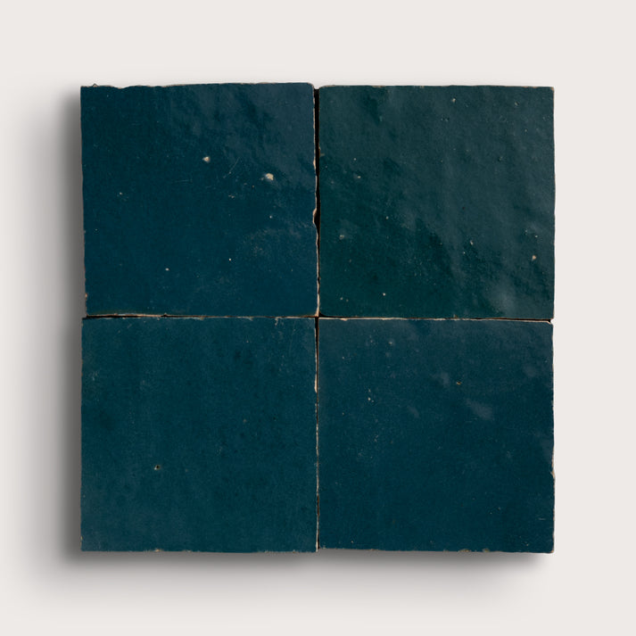 Four dark blue zellige tiles arranged in a grid pattern on a white background