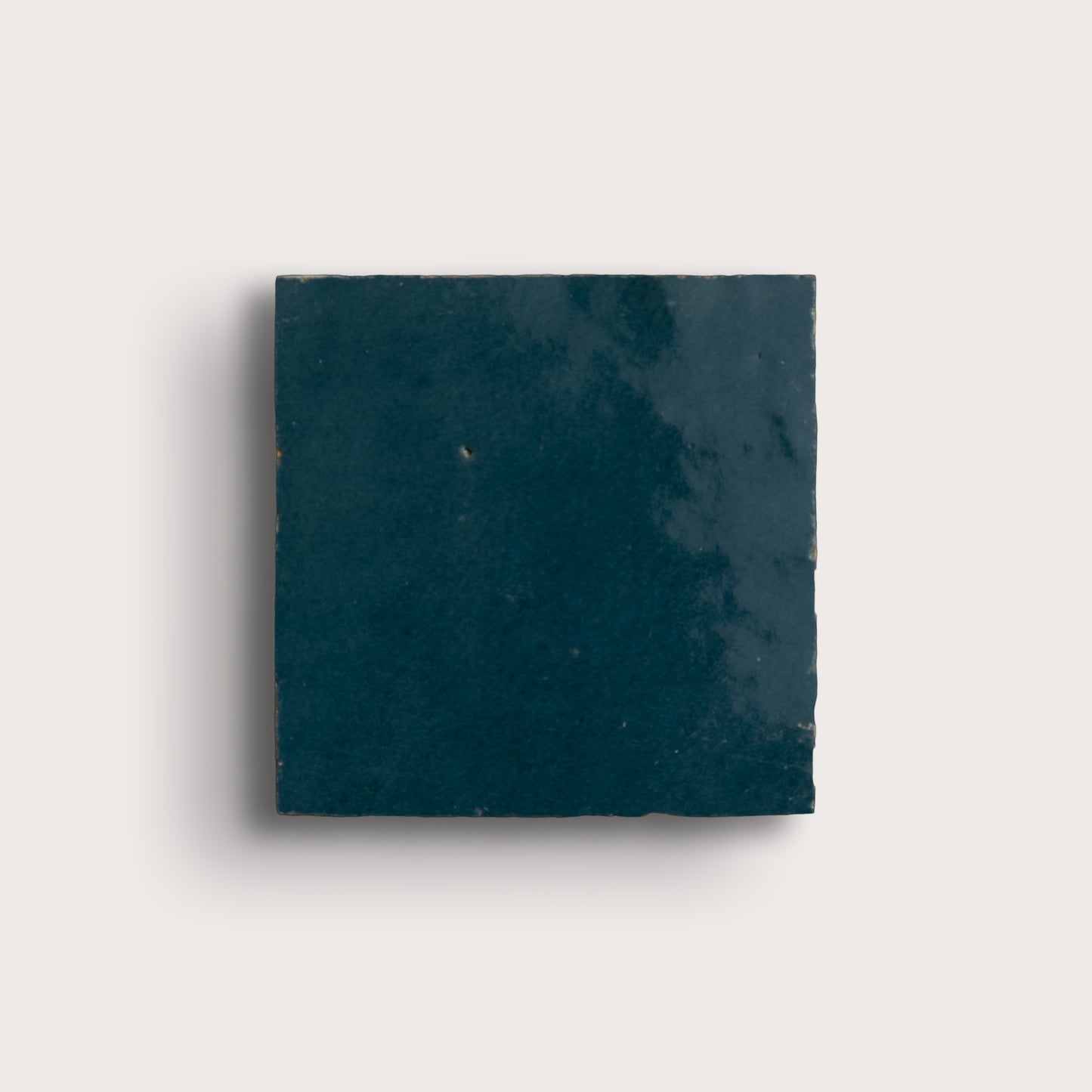 Square dark blue zellige tile on a light gray background