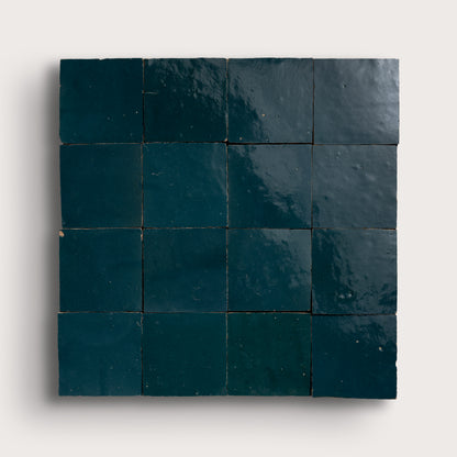 Square arrangement of dark blue zellige tiles on a white background