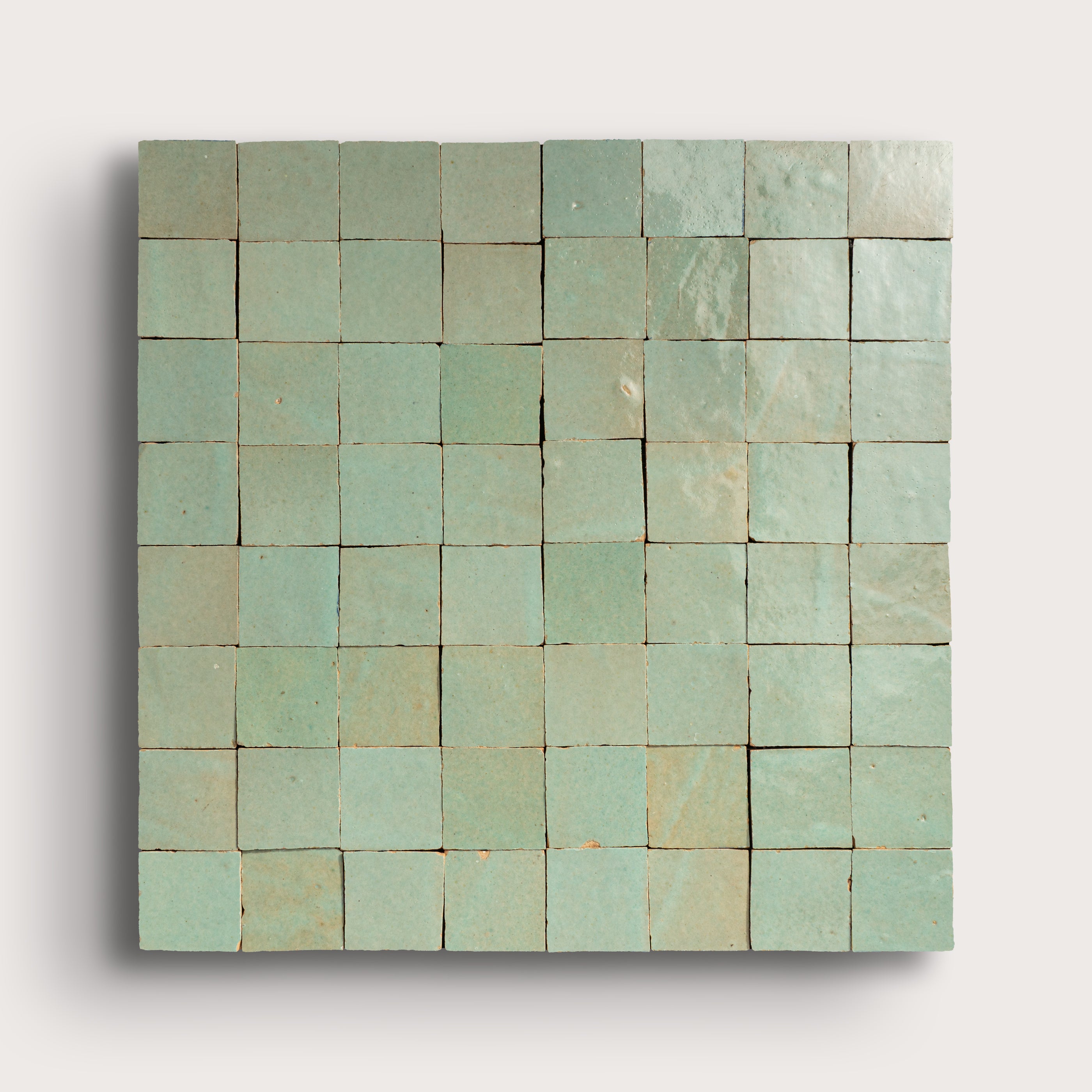 Square zellige green tile with a grid pattern on a light gray background
