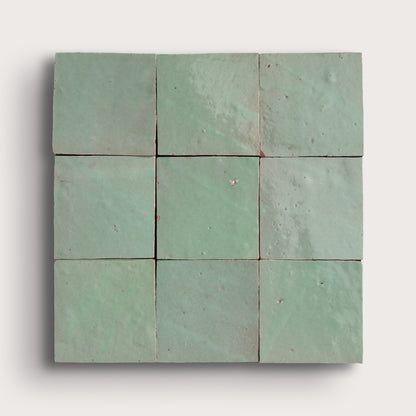 Nine square green zellige tiles arranged in a 3x3 grid on a white background