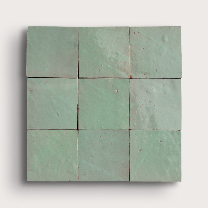 Nine square green zellige tiles arranged in a 3x3 grid on a white background