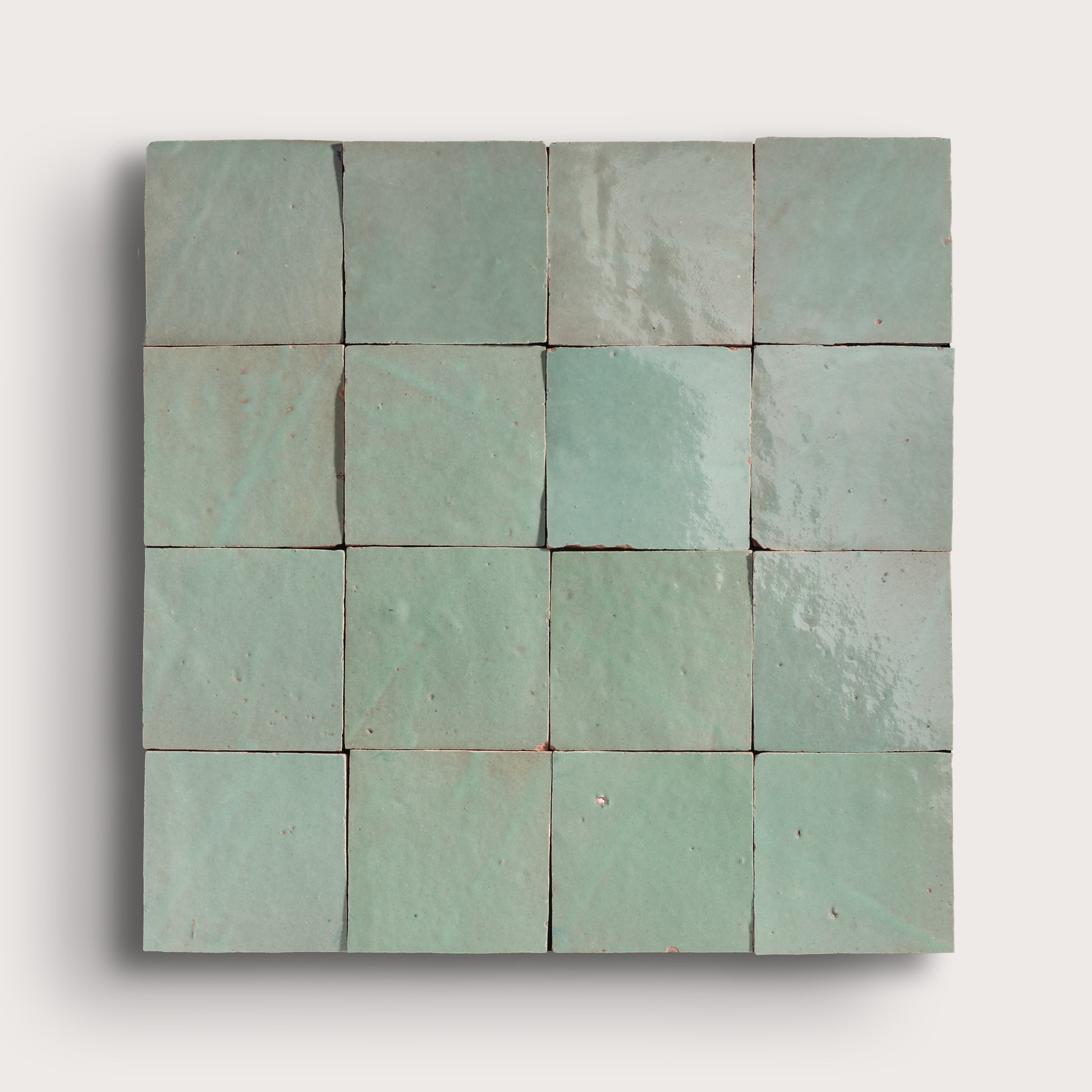 Square arrangement of green zellige tiles on a white background