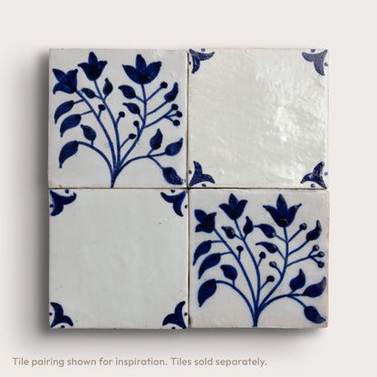 Four square zellige tiles arranged in a 2x2 grid, featuring a classic Dutch blue-and-white floral pattern on an off-white background.