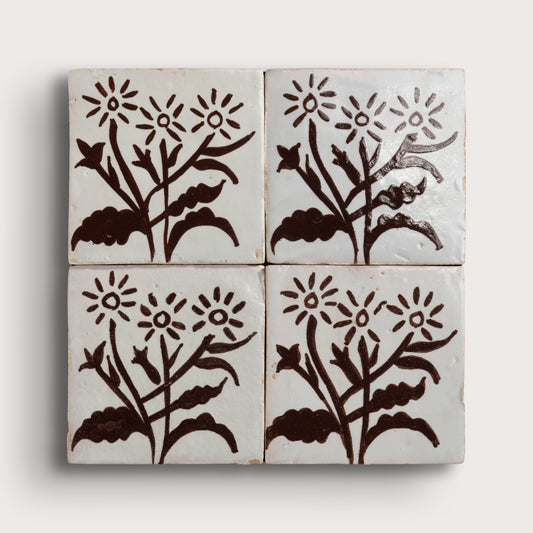 four square zellige tiles in a 2x2 grid pattern on a light gray background. Brown hand painted designs.