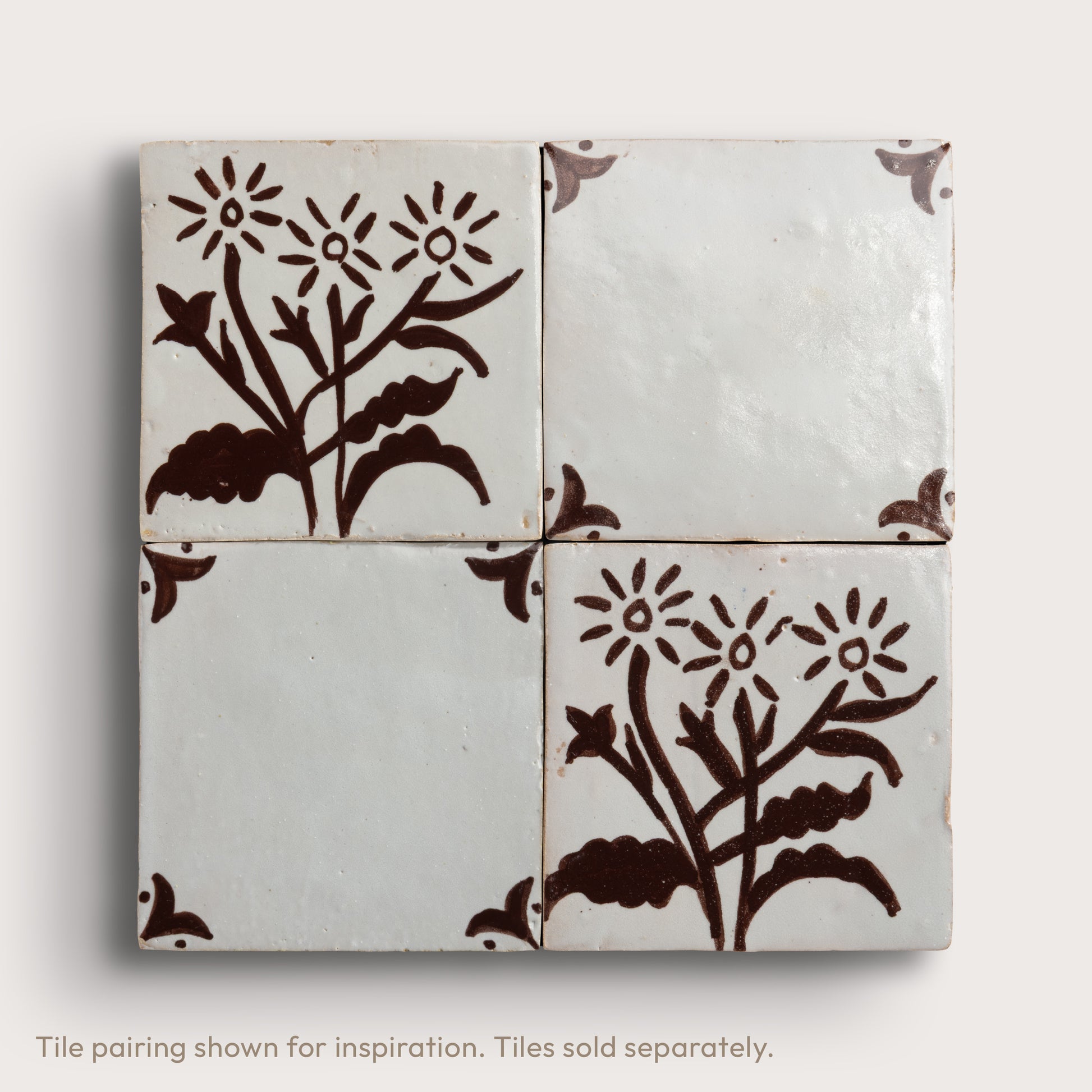 four square zellige tiles in a 2x2 grid pattern on a light gray background. Brown hand painted designs.