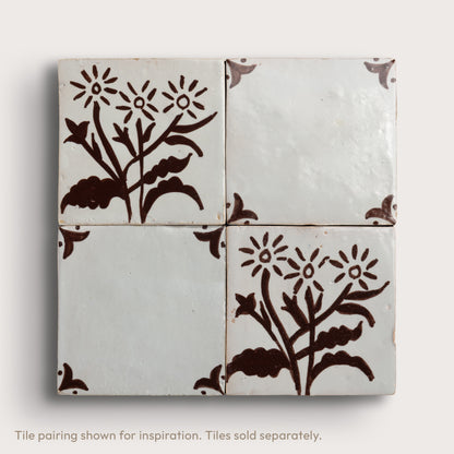 four square zellige tiles in a 2x2 grid pattern on a light gray background. Brown hand painted designs.