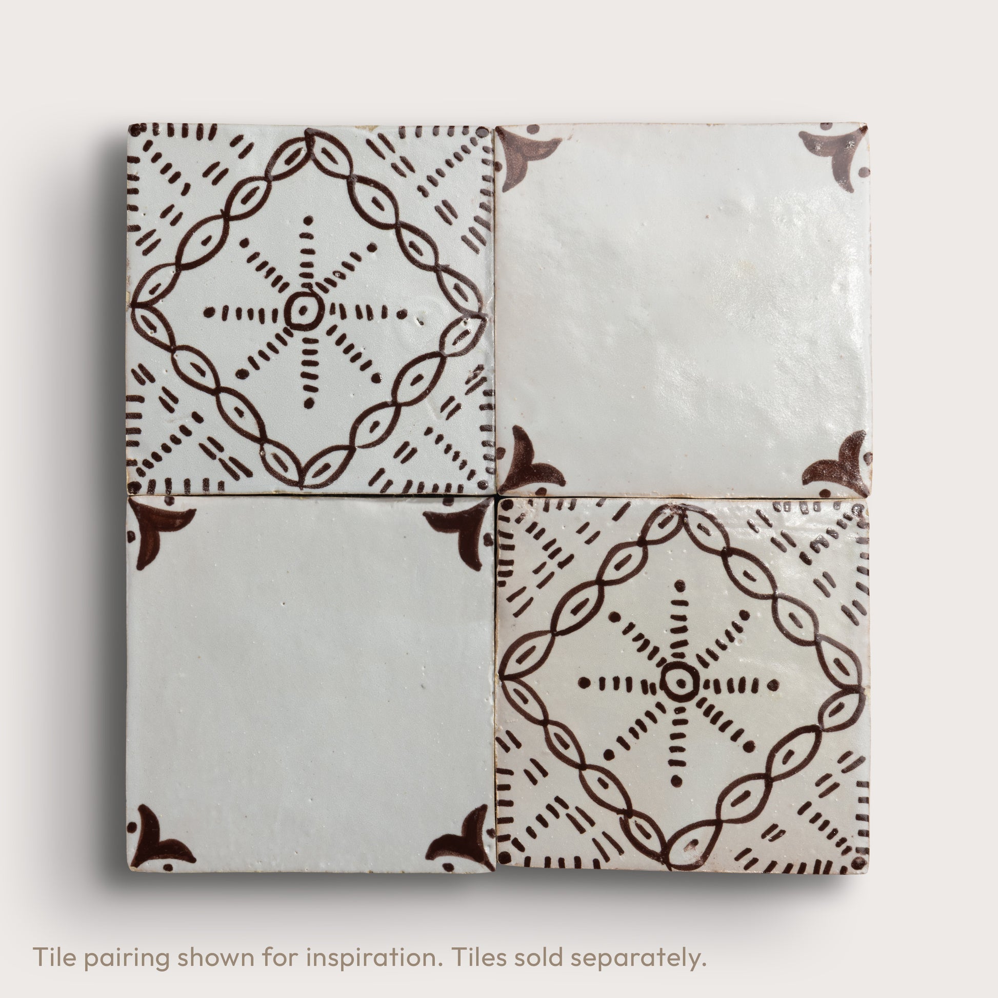 square zellige tile in a grid format with a handpainted brown pattern shot on a light gray background.