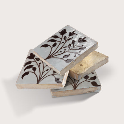 four square zellige tiles in a stacked format with handpainted brown pattern.