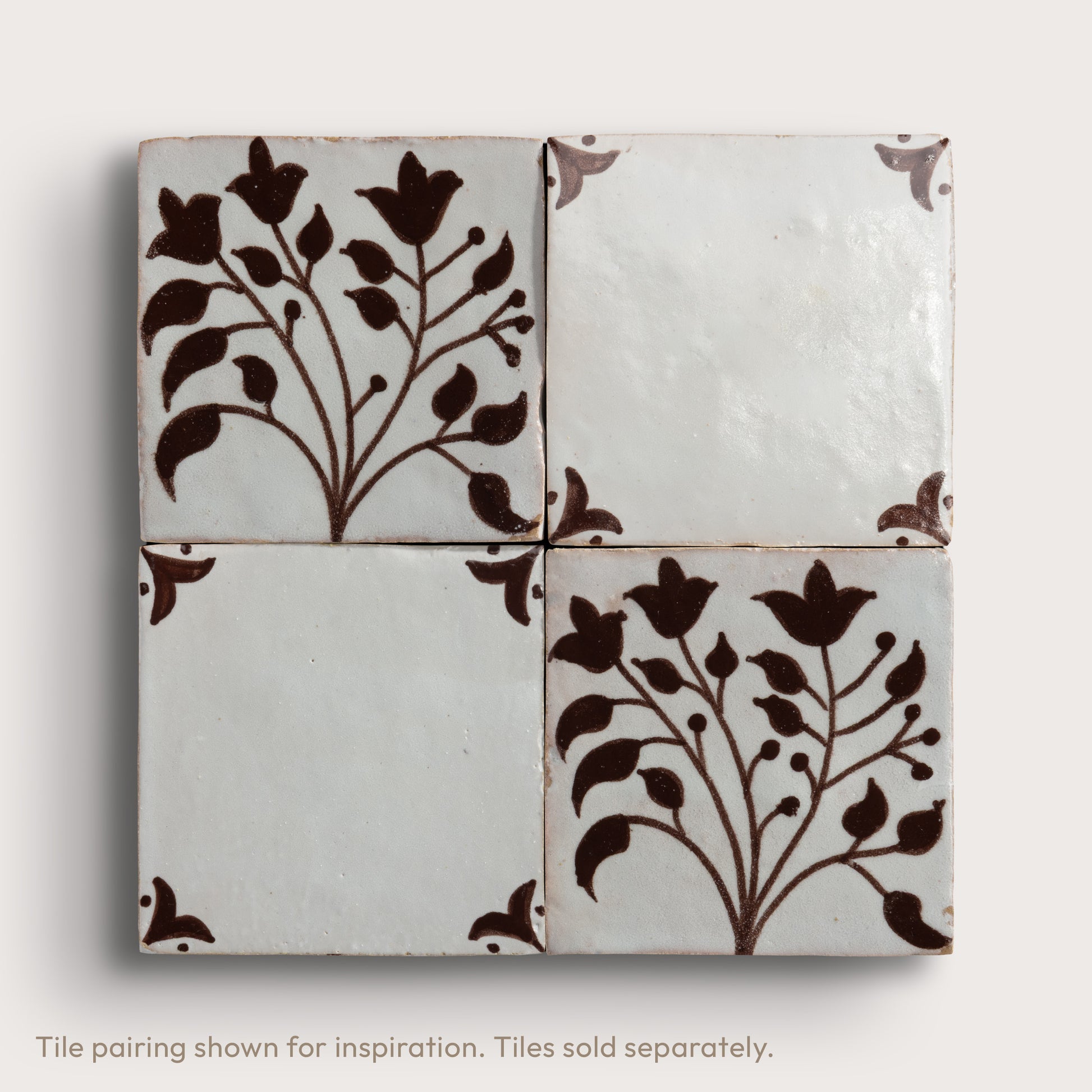 four square zellige tiles in a grid format with handpainted brown pattern.