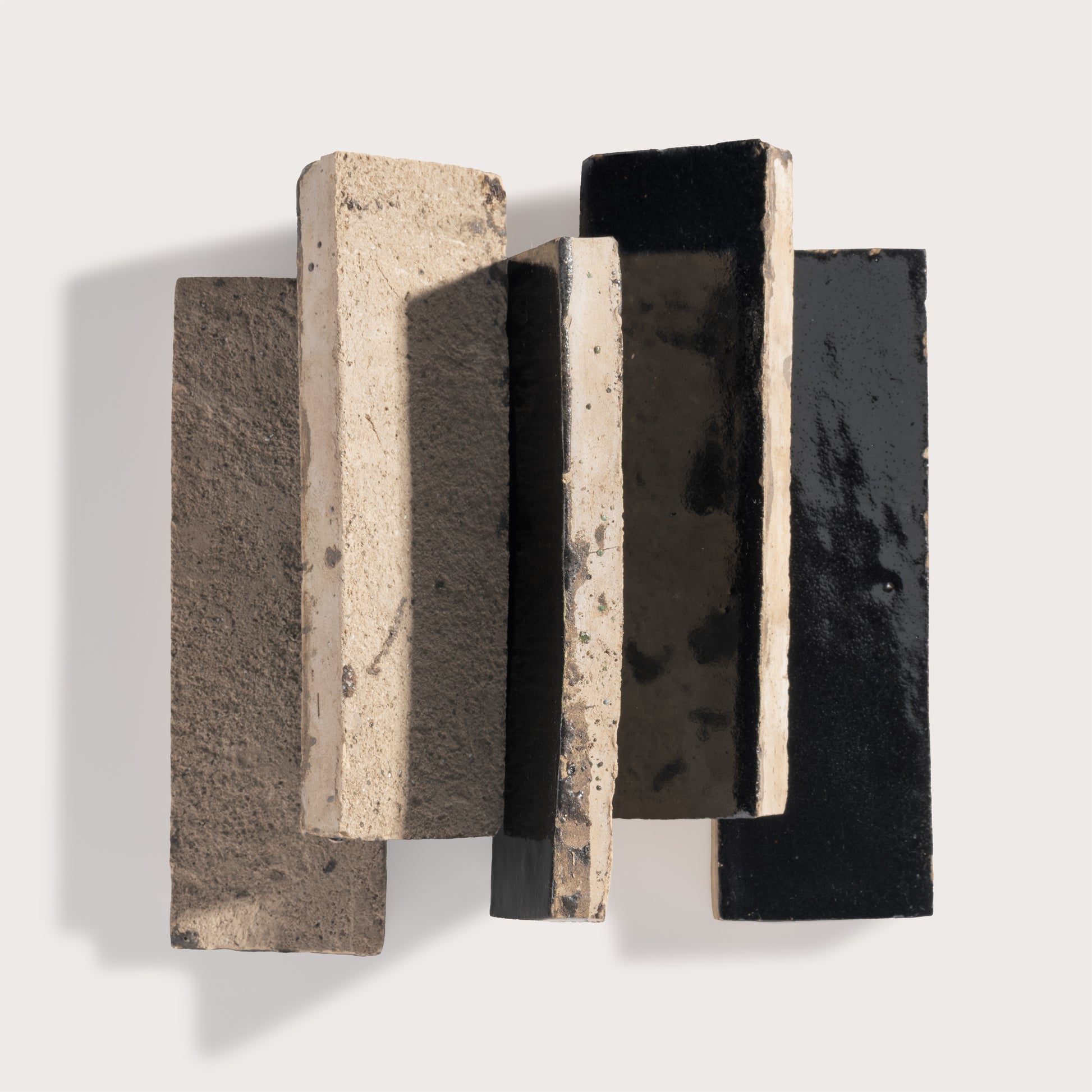Three rectangular zellige tiles with different textures on a light gray background