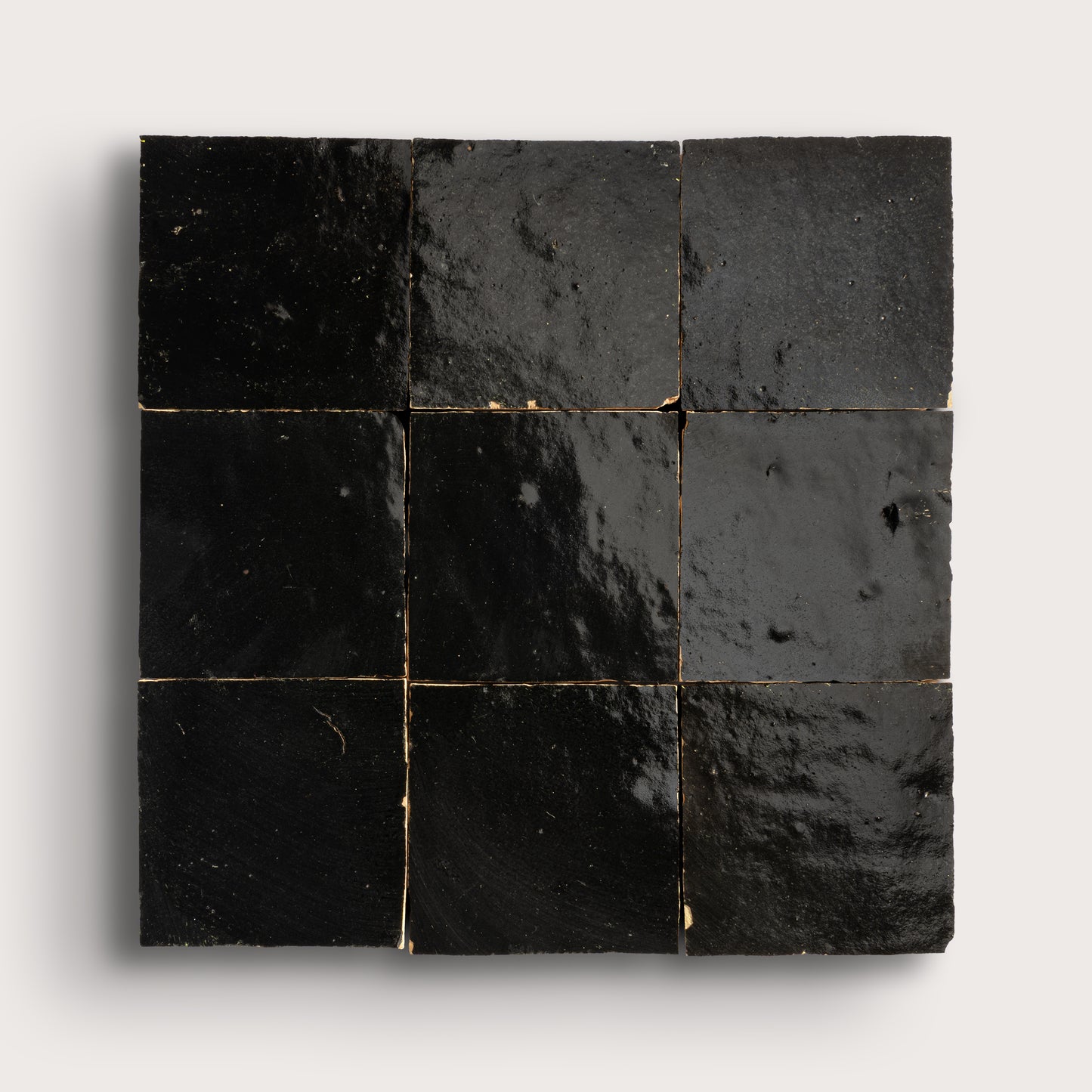 Nine black square zellige tiles arranged in a 3x3 grid on a white background